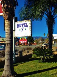 圣贝纳迪诺市中心7号汽车旅馆的棕榈树旁的汽车旅馆标志