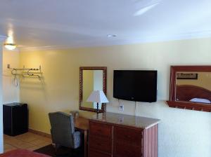 圣贝纳迪诺市中心7号汽车旅馆的一间房间,配有一张桌子和一台墙上的电视