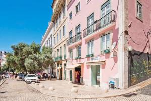 里斯本格里斯住宅酒店的粉红色建筑城市街道