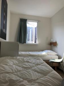 霍勒姆Appartement Waddengeluk Resort Amelander Kaap!的一间卧室设有两张床和窗户。