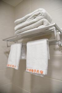 竹南竹南橘子民宿的浴室内架上的毛巾堆
