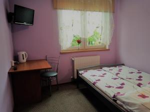 斯托尼拉斯奇Na Skwerku的一间卧室配有一张床、一张书桌和一个窗户。
