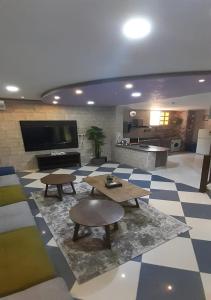 塔伊夫Al Dana Plaza Villas的客厅配有2张桌子和平面电视