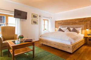 若特阿赫-埃根马勒温克尔湖滨酒店的一间卧室配有一张床、一把椅子和一张桌子