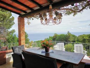 圣安德烈亚casa panoramica bouganville的一个带吊灯的庭院里的一张木桌和椅子