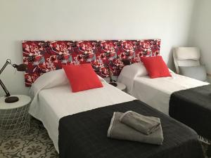 班约莱斯El Llimoner的客房内的两张床和红色枕头