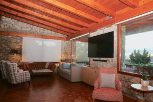 GójarFinca la Cabaña的客厅配有电视、沙发和椅子