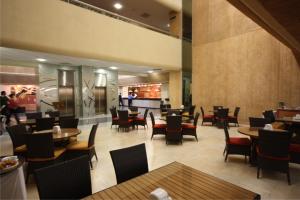 克雷塔罗Hotel Mirage - Centro Histórico de Querétaro的一间带桌椅的餐厅和一间酒吧