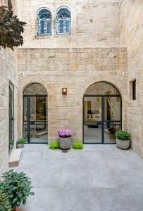 耶路撒冷Old City Boutique Hotel的一座石头建筑,设有两扇大玻璃门