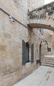 耶路撒冷Old City Boutique Hotel的砖墙,有门,有窗户和楼梯