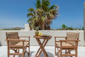 纳克索乔拉Casa Verde Di Naxos的天井上配有两把椅子和一张桌子及一碗水果