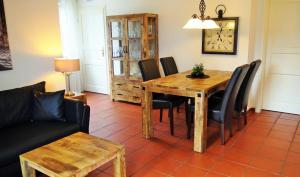 WeitnauLandhaus Petra - Die kleine Ferienvilla的用餐室配有木桌和黑椅子