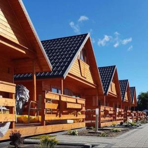 凯蒂赖贝西ATJ Bursztynowy Zakątek的有一排木结构建筑,上面有太阳能电池板