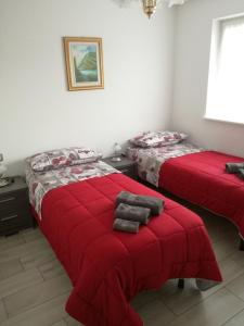 卡瓦莱塞Villa in Val di Fiemme的红色毯子的客房内的两张床