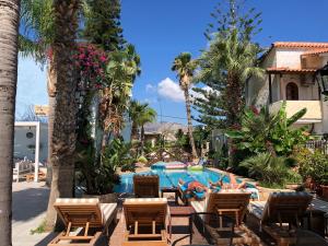 阿默达拉-伊拉克利翁米诺雅公寓酒店的一个带游泳池、椅子和棕榈树的度假村