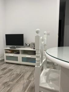 科尼尔-德拉弗龙特拉Conil Apartment的白色的客厅配有电视和桌子