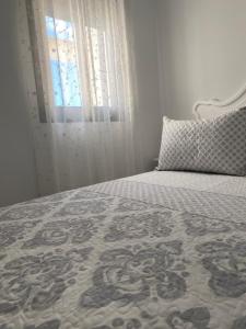 科尼尔-德拉弗龙特拉Conil Apartment的一间卧室配有一张带窗户和枕头的床
