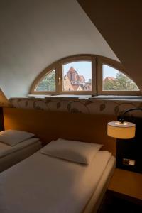 托伦布尔瓦酒店的一间卧室设有两张床和窗户。