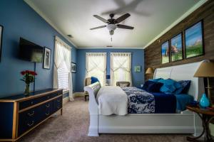 Saint JohnsThe Nordic Pineapple Bed and Breakfast的蓝色卧室配有床和吊扇