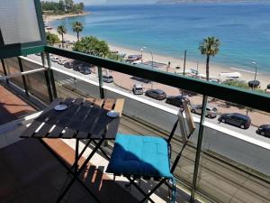 墨西拿The door of Sicily的阳台配有桌子,享有海滩美景