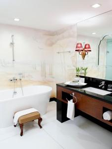 马尼拉Hotel Celeste Makati的一间带浴缸和大镜子的浴室