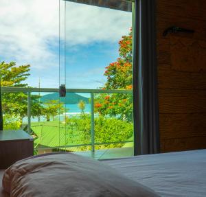 乌巴图巴绿色港湾旅舍的卧室设有海景大窗户