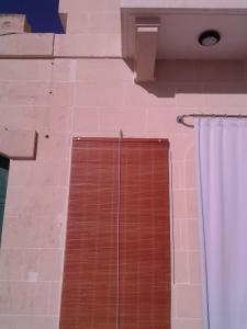 MġarrMgarr Waterfront Cosy Apartment 3 by Ghajnsielem Gozo的配有木门和窗帘的淋浴