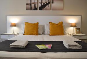 托尔博莱Blue Nest Apartment的一间卧室配有一张带黄色枕头的床和两盏灯。