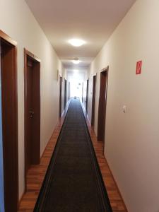 塞尼察Hotel Arli的长长的走廊,有门,地毯长