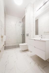 阿尔巴尤利亚阿乐格利亚酒店的白色的浴室设有卫生间和水槽。