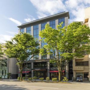 金泽First Hotel Kanazawa的前面有树木的办公楼