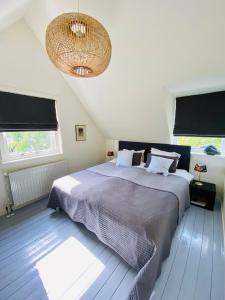 卑尔根Tiny House De Oude Berg的一间卧室配有一张大床和一个吊灯。