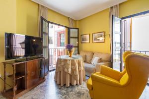 塞维利亚Alfalfa Deluxe Suite by Valcambre的客厅配有电视、沙发和桌子