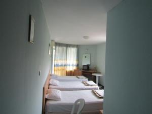 瓦尔纳Hostel Papagal的客房设有两张床、一张桌子和一面镜子。