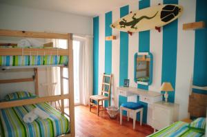 卢斯Jho'La Surf Camp的卧室配有双层床,墙上设有冲浪板