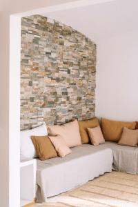 巴古尔Apartaments Cap Sa Sal的客厅配有沙发,靠砖墙
