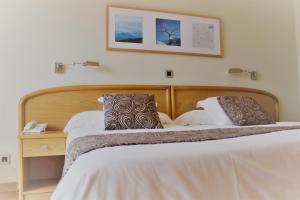 贝尼多姆塔尼特酒店的卧室配有两张床,墙上挂着一幅画