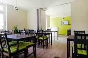 德绍Clubhostel Dessau的用餐室设有桌椅和绿色的墙壁