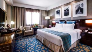 迪拜迪拜迪尔拉皇冠假日酒店的酒店客房设有一张大床和一张书桌。