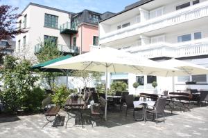 布里隆Hotel zur Post的一个带桌椅和遮阳伞的户外庭院。