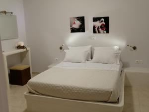 纳克索斯岛卡斯特拉基Sahara Apartments的一间白色卧室,配有一张床和浴缸