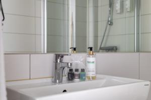 弗加尔巴卡Bryggan Fjällbacka的浴室水槽配有2瓶肥皂和镜子