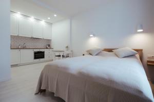 帕兰加Pas Aldona的一间白色卧室,配有一张大床和一个厨房