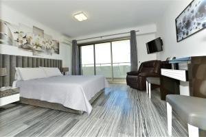 波尔蒂芒Exclusive Luxury Apartments in Oceano Atlantico Complex的一间卧室配有一张床、一张沙发和一台电视