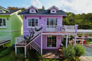 春武里Bunny Hill Resort的紫色的房子,设有门廊和甲板
