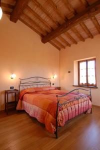 乌尔巴尼亚Sant'Angiolino的一间卧室配有一张带红色棉被的床和窗户。