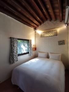 安平区漫步巷弄的卧室设有一张白色大床和一扇窗户。