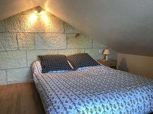 谢尔河畔圣乔治l'Ecrin au coeur des vignes的一间卧室设有一张床和石墙