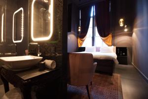 哈莱姆斯塔茨精品酒店的一间带水槽的浴室和一间带一张床的卧室