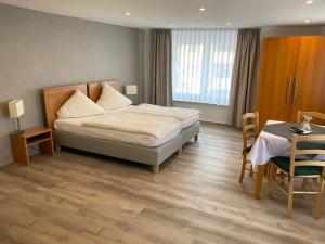 巴特迪尔海姆伽斯特翰斯基瑟拉酒店的酒店客房带一张床、一张桌子和椅子